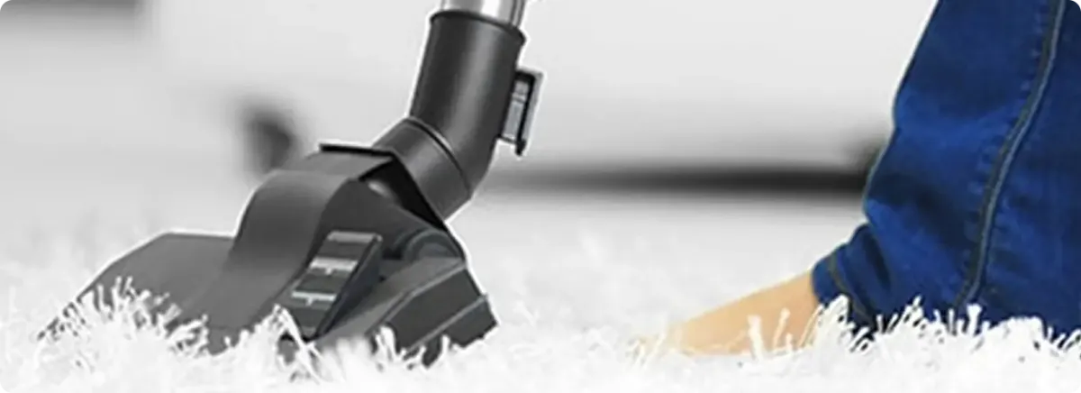 Close-up of a professional vacuuming a white carpet in Lamont.
